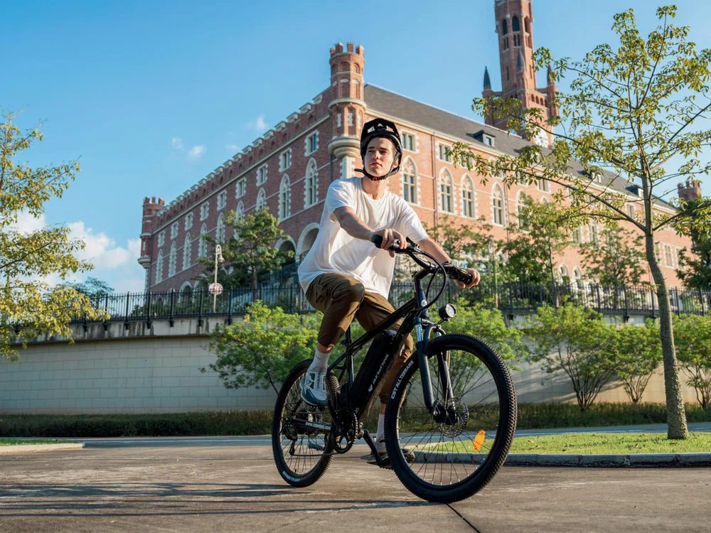A rider on an isinwheel e-bike in front of a historic building