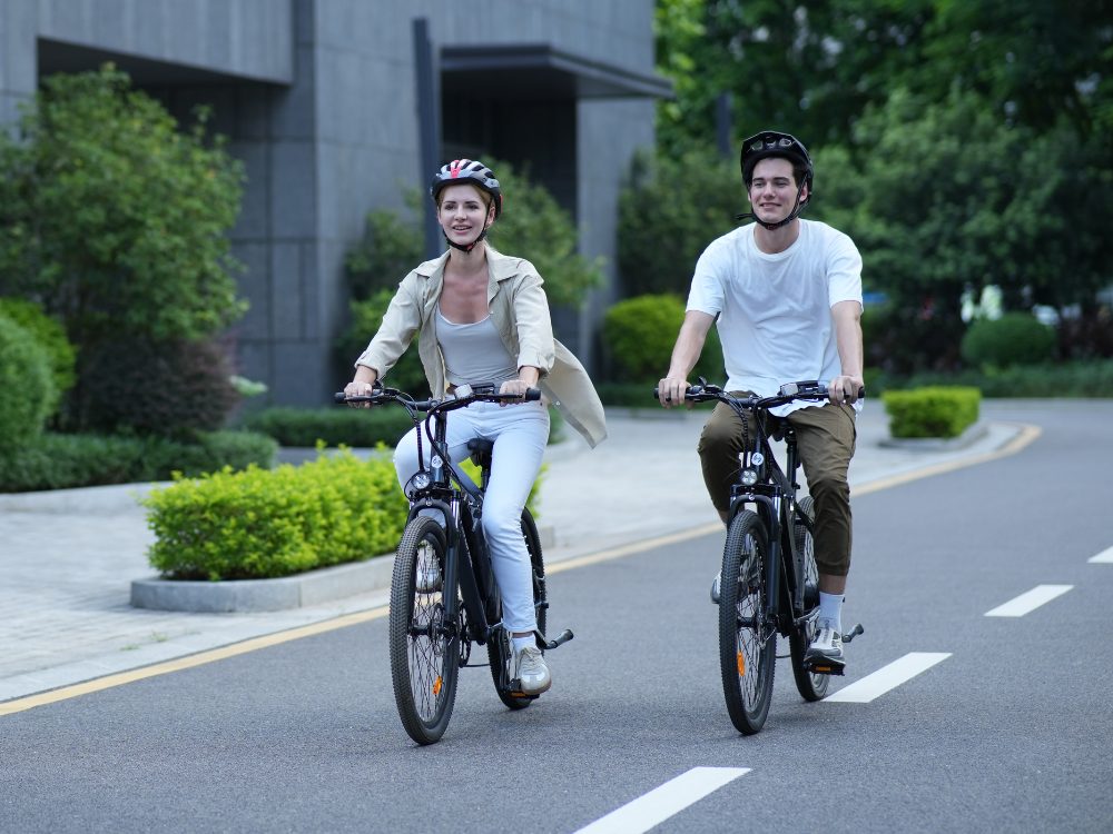 Two riders on isinwheel city e-bikes riding along a city road
