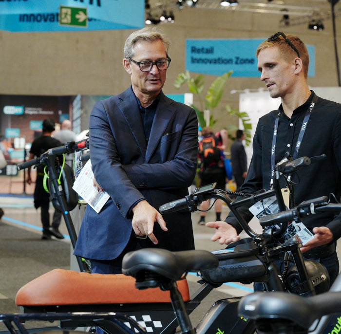 Deux visiteurs examinent de près les vélos électriques du stand